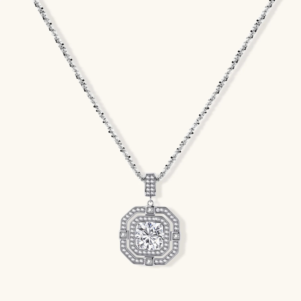 Sterling silver octagonal pendant necklace with brilliant moissanite center stone and halo setting on white background.