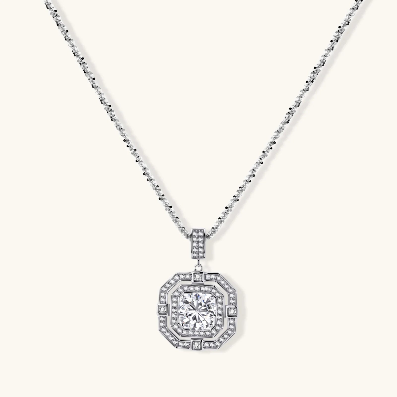 Sterling silver octagonal pendant necklace with brilliant moissanite center stone and halo setting on white background.