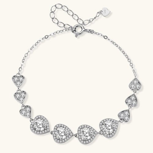 Sterling silver bracelet with graduated heart-shaped links and sparkling moissanite stones in VVS1 clarity on white background.