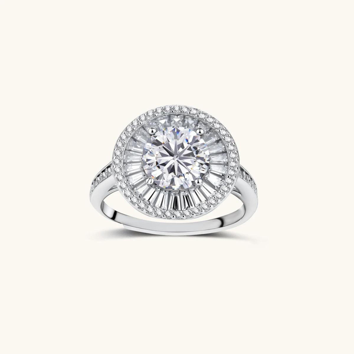 Brilliant round moissanite center stone with baguette and round halo accents in sterling silver setting on light background.