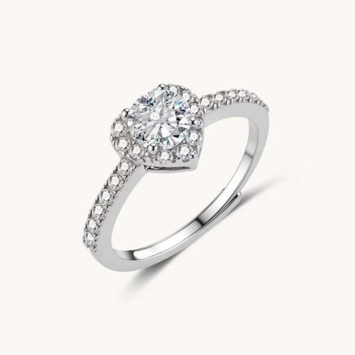 Heart-shaped halo ring with brilliant moissanite center stone surrounded by smaller crystals in sterling silver setting