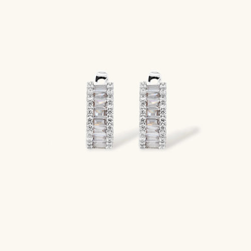White gold plated necklace with vertical cubic zirconia pendant and matching hoop earrings on neutral background