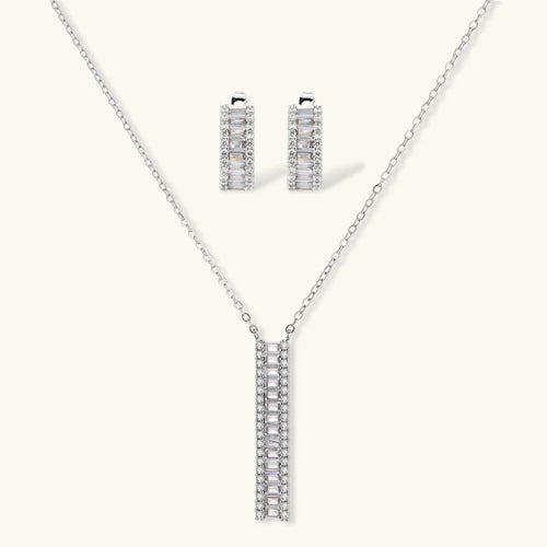 White gold plated necklace with vertical cubic zirconia pendant and matching hoop earrings on neutral background