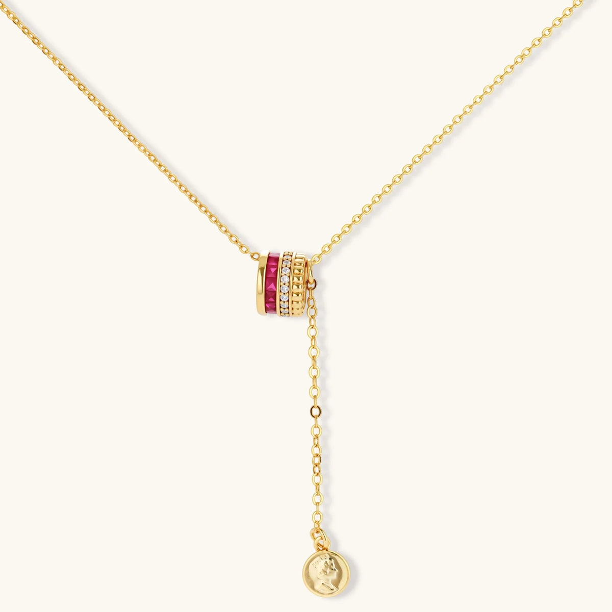 Three-piece jewelry set featuring 14K gold plated pieces with deep red cubic zirconia stones and clear crystals on cream background.