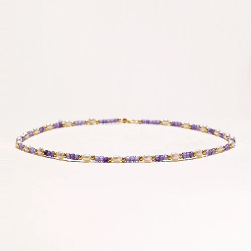 Delicate 18K gold vermeil necklace with alternating lavender zirconia beads and white freshwater pearls on cream background