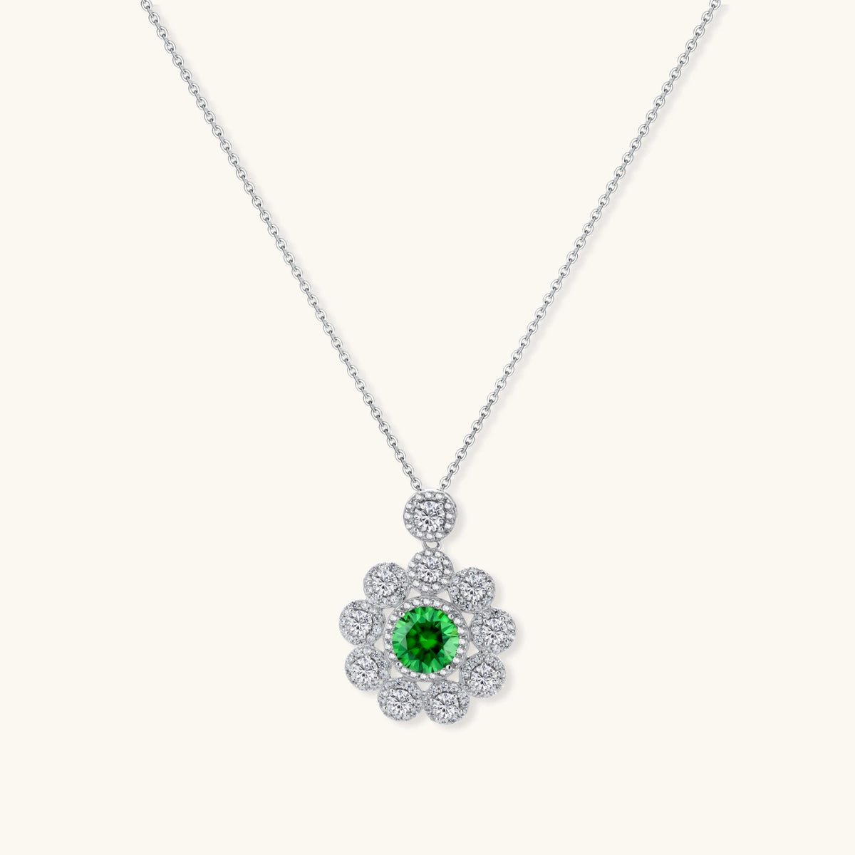 Delicate sterling silver necklace with flower-shaped pendant featuring bright green center moissanite and clear accent stones