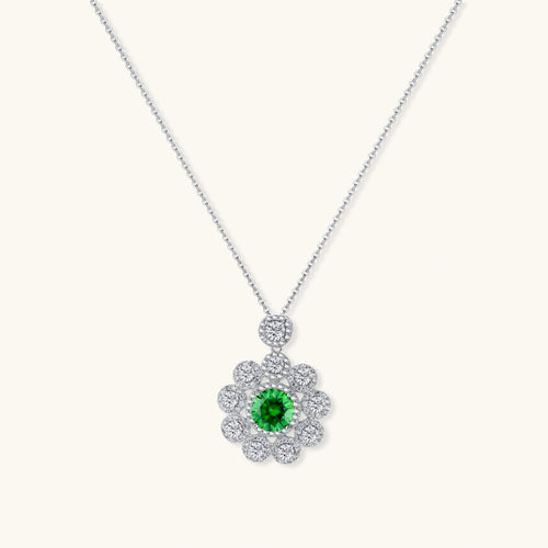 Delicate sterling silver necklace with flower-shaped pendant featuring bright green center moissanite and clear accent stones
