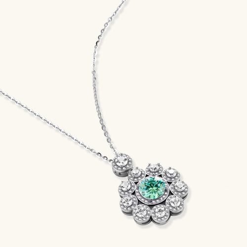 Delicate sterling silver necklace with flower-shaped pendant featuring bright green center moissanite and clear accent stones