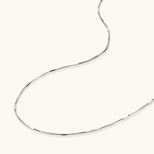 Delicate platinum-plated sterling silver necklace with alternating textured cubic links and smooth chain sections.
