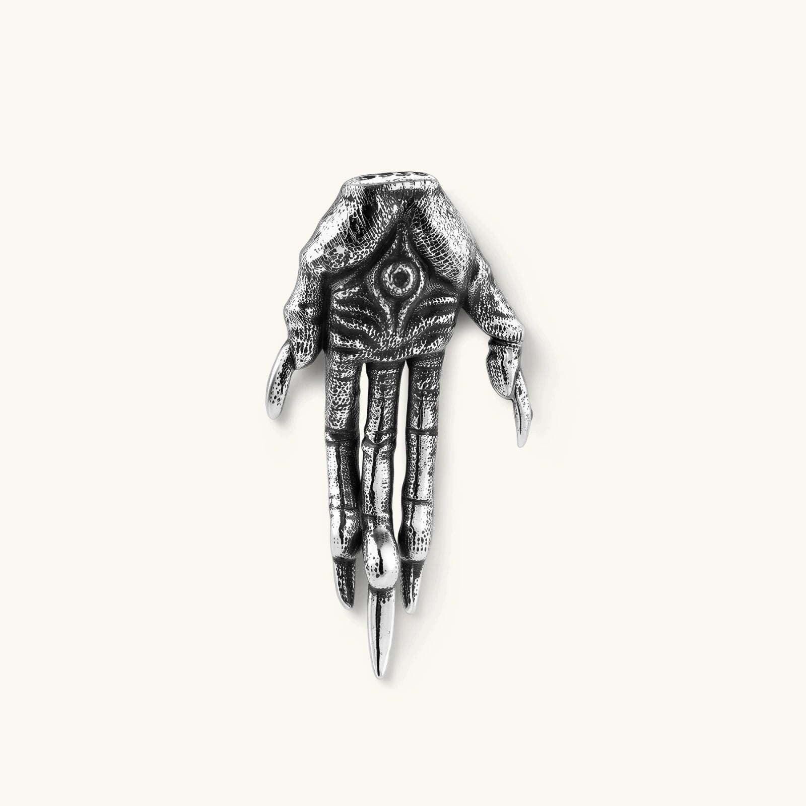 Silver stainless steel stud earring shaped like a skeletal demon claw hand with an eye motif on the palm and sharp talon fingers.