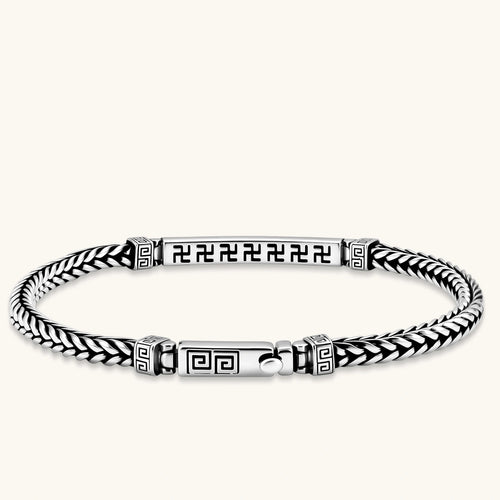 Silver stainless steel men's bracelet with braided foxtail chain, Greek key engraved bar, and decorative cube connectors.