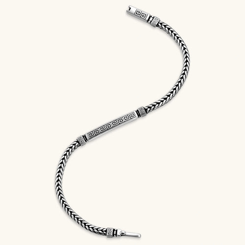 Silver stainless steel men's bracelet with braided foxtail chain, Greek key engraved bar, and decorative cube connectors.