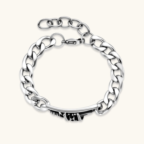 Silver 316L stainless steel Cuban chain bracelet with blackened skull and crown ID bar centerpiece, lobster clasp closure.