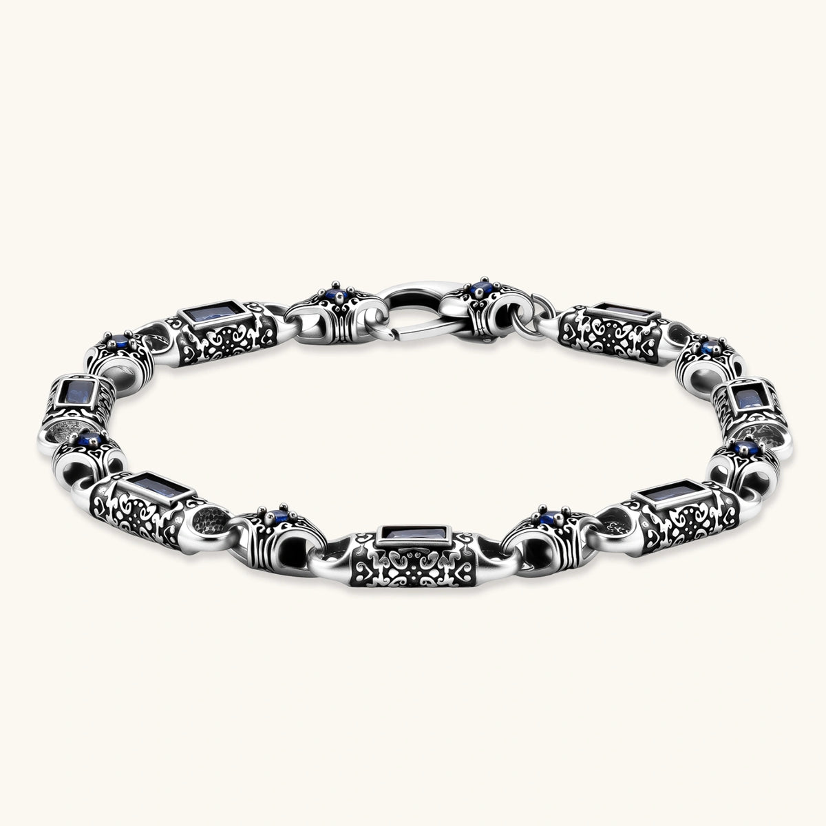 Oxidized silver stainless steel link bracelet with baguette blue CZ stones and intricate scroll engravings, lobster clasp.