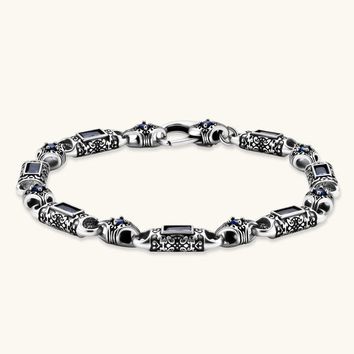 Oxidized silver stainless steel link bracelet with baguette blue CZ stones and intricate scroll engravings, lobster clasp.