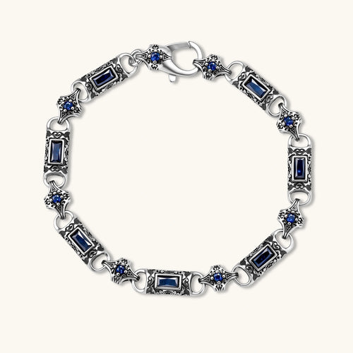 Oxidized silver stainless steel link bracelet with baguette blue CZ stones and intricate scroll engravings, lobster clasp.