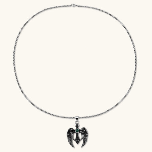 Silver stainless steel angel wing cross pendant necklace with green CZ center stone and black crystals on a box chain.